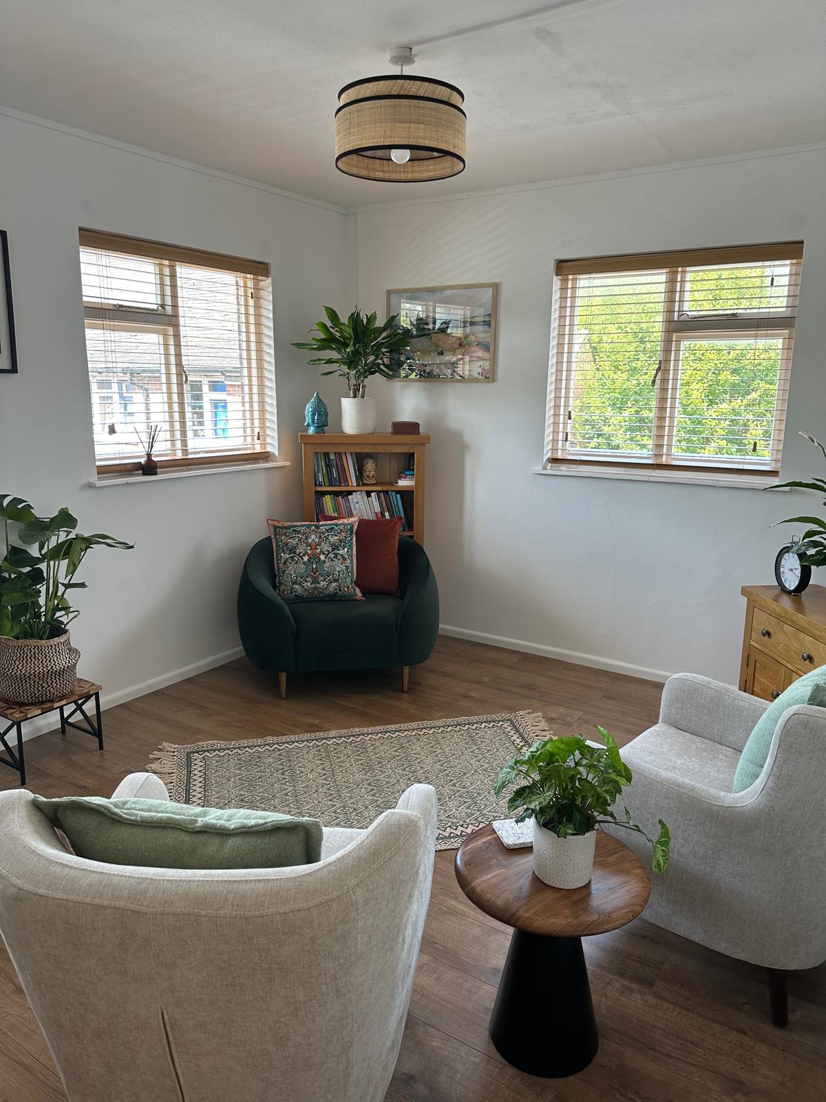 Nikki's office with three chairs plants and a bookcase.